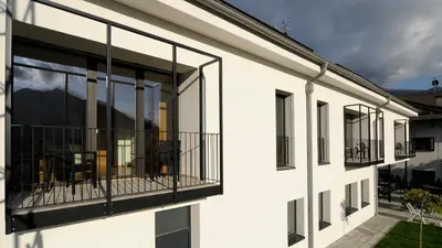 a white building with large glass windows at Residence Bar Pizzeria Sylvanerhof in Naz-Sciaves