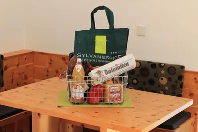 a basket of food on a table with a shopping bag at Residence Bar Pizzeria Sylvanerhof in Naz-Sciaves