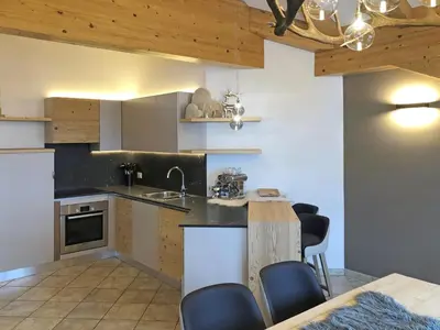 a kitchen with a table and some chairs in it at Attico Faloria Luxury in Moena
