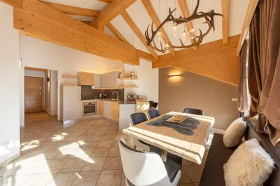 a kitchen and dining room with a table and chairs at Attico Faloria Luxury in Moena