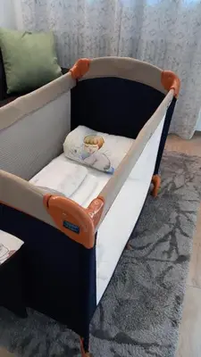 a baby crib with an orange and white crib at MAISON MY LIFE in Bolzano