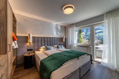 a bedroom with a large bed and a window at Tyrol family retreat in Naturno