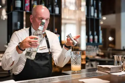 a man standing behind a bar holding a drink at Tyrol family retreat in Naturno