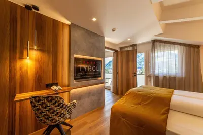 a hotel room with a bed and a chair at Tyrol family retreat in Naturno