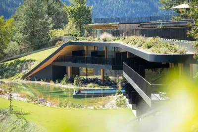 a house with a garden on the side of it at Ansitz Velseck-Residence Hotel in Tires