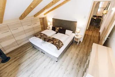 a bedroom with a bed with white sheets and pillows at Residence Paulserhof in Appiano sulla Strada del Vino