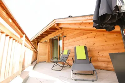 two chairs on a porch of a log cabin at Residence Paulserhof in Appiano sulla Strada del Vino