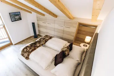 a bedroom with a bed and a couch at Residence Paulserhof in Appiano sulla Strada del Vino
