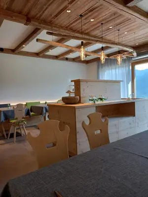 a kitchen with a counter and chairs in a room at Agriturismo Maso Schneider in Cavalese