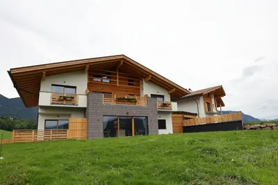 a house on top of a grassy hill at Agriturismo Maso Schneider in Cavalese