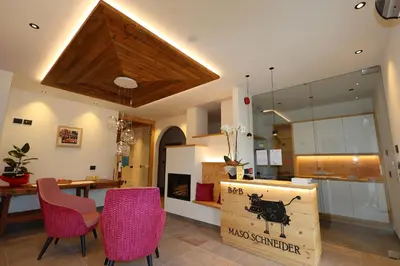 a room with a table and chairs and a cow sign at Agriturismo Maso Schneider in Cavalese