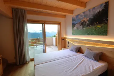 a bedroom with a bed and a picture of a cow on the wall at Agriturismo Maso Schneider in Cavalese