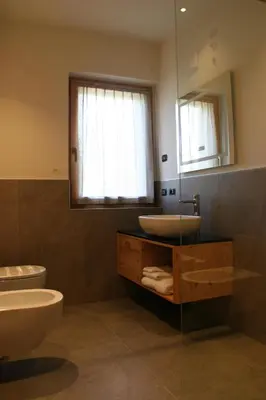 a bathroom with a sink and a toilet and a mirror at Agriturismo Maso Schneider in Cavalese