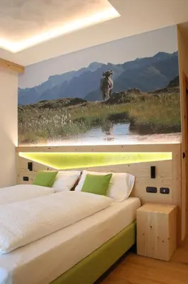 a bedroom with a bed with a painting of a cow at Agriturismo Maso Schneider in Cavalese