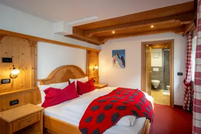 a bedroom with a bed with a black and white comforter at B&B Cesa Marlen in Canazei