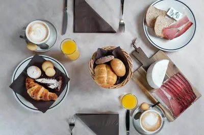 a table with plates of breakfast foods and drinks at B&B Cesa Marlen in Canazei