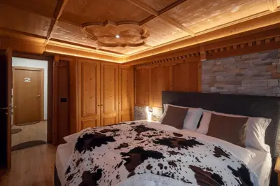 a bedroom with a bed with a red blanket at B&B Cesa Marlen in Canazei