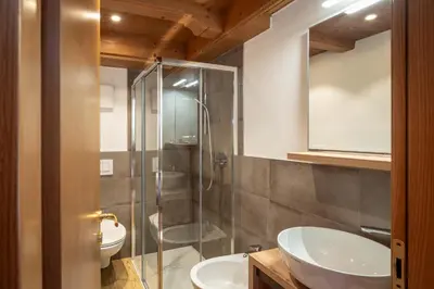 a bathroom with a glass shower and two sinks at B&B Cesa Marlen in Canazei