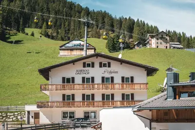 a building on a ski slope with a ski lift at Hotel B&B Frohsinn in Badia