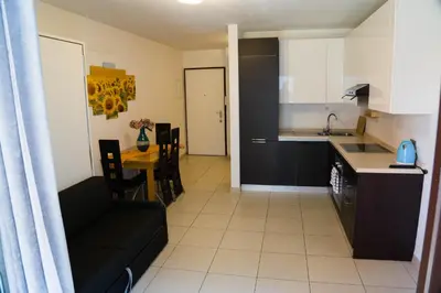 a kitchen and a living room with a couch and a table at Casa Margherita in Bolzano