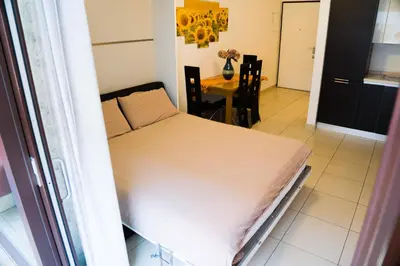 a large bed in a room with a table at Casa Margherita in Bolzano