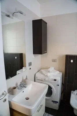 a bathroom with a washing machine and a sink at Casa Margherita in Bolzano