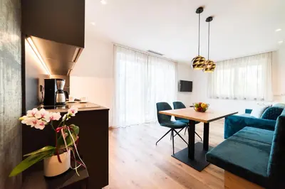 a kitchen and living room with a table and a couch at Marlingsuites in Marlengo