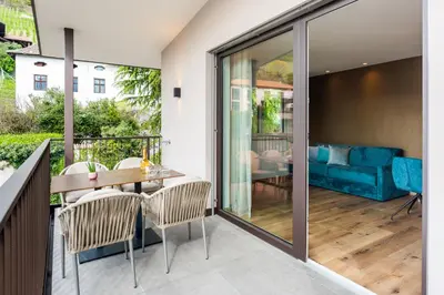 a balcony with a table and chairs and a couch at Marlingsuites in Marlengo