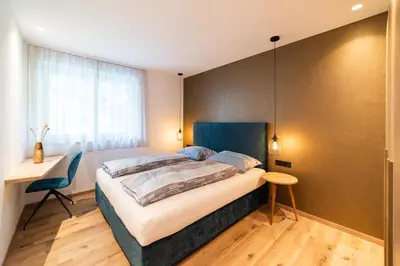 a bedroom with a large bed and a desk at Marlingsuites in Marlengo