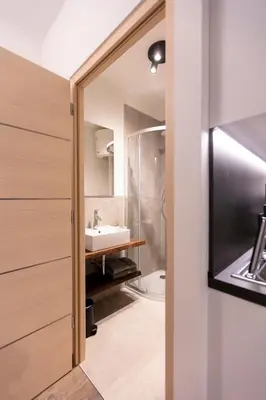 a bathroom with a sink and a mirror at Modern studio apartment in the heart of Merano in Merano