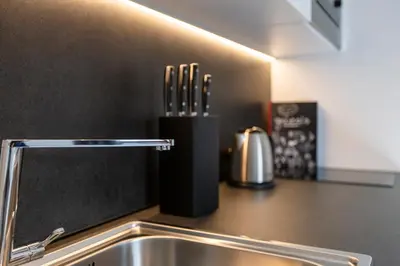 a kitchen counter with a sink and a knife holder at Modern studio apartment in the heart of Merano in Merano