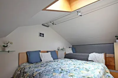 a bedroom with a bed with blue pillows at Wonderful Attic in Dolomite's Heart in Selva di Cadore