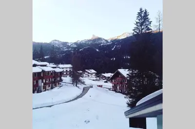 a snow covered village with houses and a road at Wonderful Attic in Dolomite's Heart in Selva di Cadore