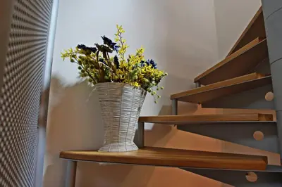 a vase with flowers sitting on a shelf at Wonderful Attic in Dolomite's Heart in Selva di Cadore