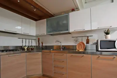 a kitchen with white cabinets and a microwave at Wonderful Attic in Dolomite's Heart in Selva di Cadore