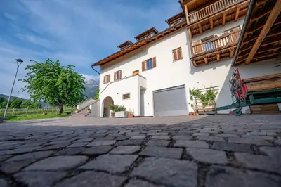 a stone driveway in front of a white house at Weingut Lahn zu Eppan in Appiano sulla Strada del Vino