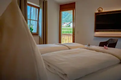 a row of beds in a room with a window at Weingut Lahn zu Eppan in Appiano sulla Strada del Vino