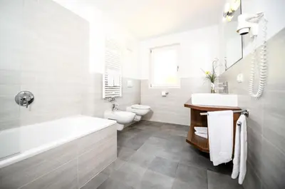 a bathroom with a tub and a sink and a toilet at Apartments Sunela in Selva di Val Gardena