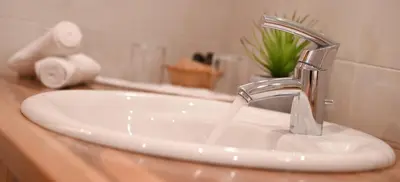 a bathroom sink with water running from a faucet at Apartments Sunela in Selva di Val Gardena
