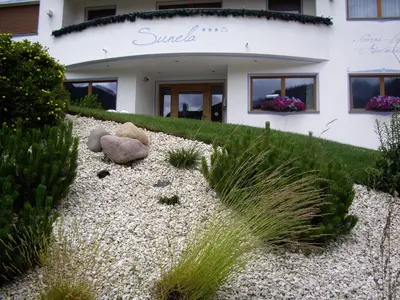 a house with a teddy bear sitting in front of it at Apartments Sunela in Selva di Val Gardena