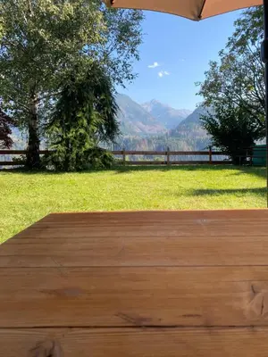a wooden table with a view of the mountains at Appartamenti Pichler in Castello di Fiemme