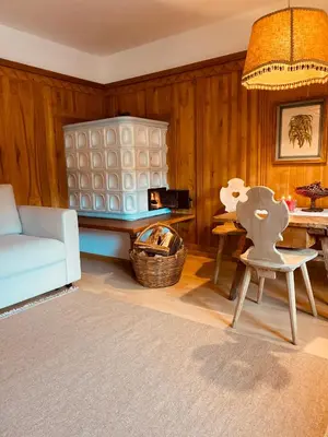 a living room with a blue couch and a chair at Appartamenti Pichler in Castello di Fiemme