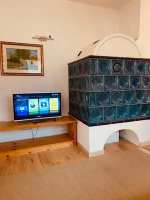a living room with a tv and a fireplace at Appartamenti Pichler in Castello di Fiemme