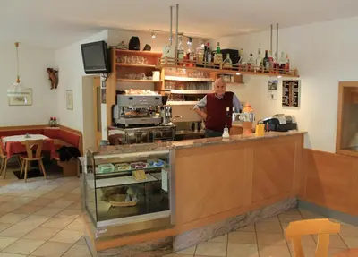 a man standing behind a counter in a kitchen at Gasthof Bundschen in Sarntal