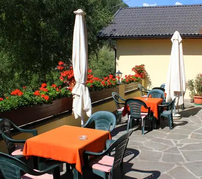 a row of tables and chairs with umbrellas on a patio at Gasthof Bundschen in Sarntal