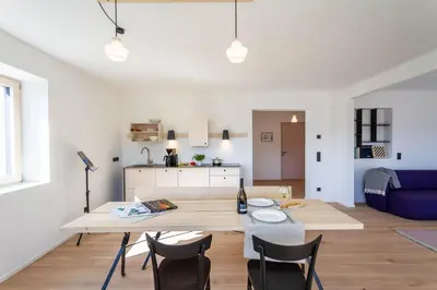 a kitchen and living room with a table and chairs at Residence Villa Schlern in Fiè
