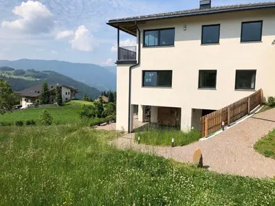 a house on top of a hill with a field at Residence Villa Schlern in Fiè