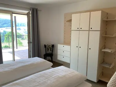 a bedroom with a bed and a cabinet and a window at Residence Villa Schlern in Fiè