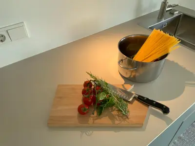a cutting board with vegetables and a knife on a counter at Residence Villa Schlern in Fiè