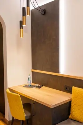 a wooden table with two yellow chairs and a blackboard at Hotel Garni Christin in Ora/Auer